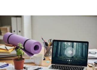 Top Employee Wellness Programs for a Healthier Workplace A messy office desk with a sad succulent, a yoga mat, and a laptop showing a mindfulness app.