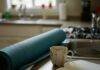 Health and Wellness Coaching: Transform Your Life in 2025 A kitchen counter with a blue yoga mat, a broken coffee mug, and a notebook with a coffee stain.