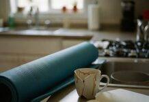 Health and Wellness Coaching: Transform Your Life in 2025 A kitchen counter with a blue yoga mat, a broken coffee mug, and a notebook with a coffee stain.