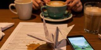 How Mental Health Awareness in 2025 Is Totally Rewiring Our Lives A cozy coffee shop table with a spilled latte, a paper crane, a phone with a mindfulness app, and a smiley-face sock peeking out.