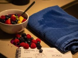 The Role of Nutritionists for Athletes: Optimize Your Performance in 2025 A smoothie bowl with spilled berries, a blue gym towel, and a doodled notepad on a counter.