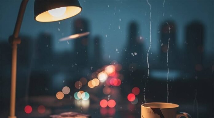 Why Mental Health Education is Critical for Our Future—A Deep Dive A blurry, photorealistic image of a messy desk with a doodle-filled notebook, a chipped "Keep Going" mug, and a city skyline visible through a streaky window.