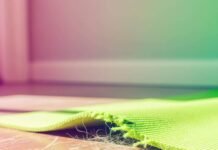 op Sleep Disorder Resources: Everything You Need to Sleep Soundly A close-up of a torn green mat on a wooden floor, with pet hair and scratches visible.