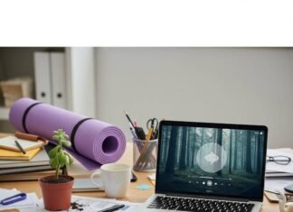 Top Employee Wellness Programs for a Healthier Workplace A messy office desk with a sad succulent, a yoga mat, and a laptop showing a mindfulness app.