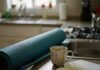 Health and Wellness Coaching: Transform Your Life in 2025 A kitchen counter with a blue yoga mat, a broken coffee mug, and a notebook with a coffee stain.