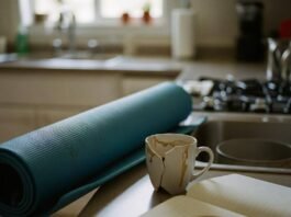 Health and Wellness Coaching: Transform Your Life in 2025 A kitchen counter with a blue yoga mat, a broken coffee mug, and a notebook with a coffee stain.