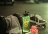 Why Hiring a Fitness Coach Near You Will Jumpstart Your Goals A sweaty gym towel on a dumbbell, a water bottle with a sticker, a crumpled workout plan, and a sneaker on a gym floor